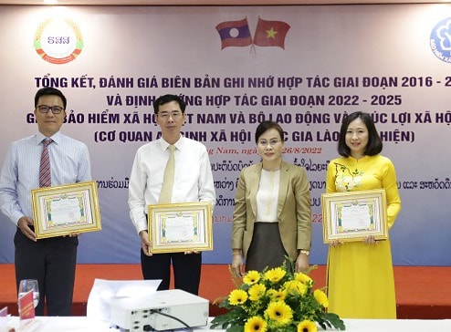 Cơ quan BHXH Quốc gia Lào trao bằng khen cho các cá nhân của Việt Nam có nhiều đóng góp trong hợp tác lĩnh vực an sinh xã hội giữa hai quốc gia. Ảnh: D.L
