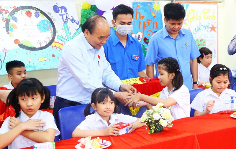 Chủ tịch nước Nguyễn Xuân Phúc tặng quà trẻ em. Ảnh: Báo Hà Nội mới