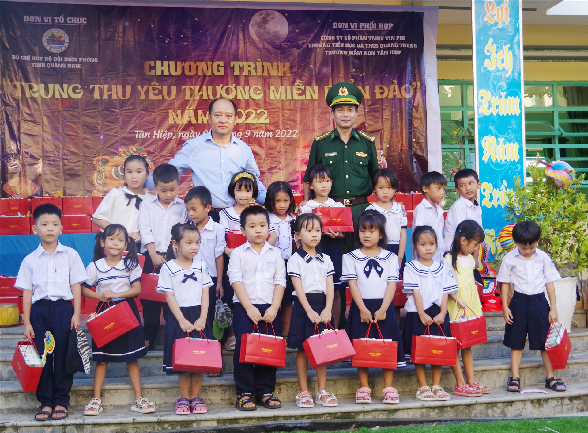 Đại tá Hoàng Văn mẫn - Chính ủy BĐBP tỉnh và đại diện Công ty cổ phần TMDV Tín Phi tặng àu cho các cháu thiếu nhi. Ảnh: HỒNG ANH