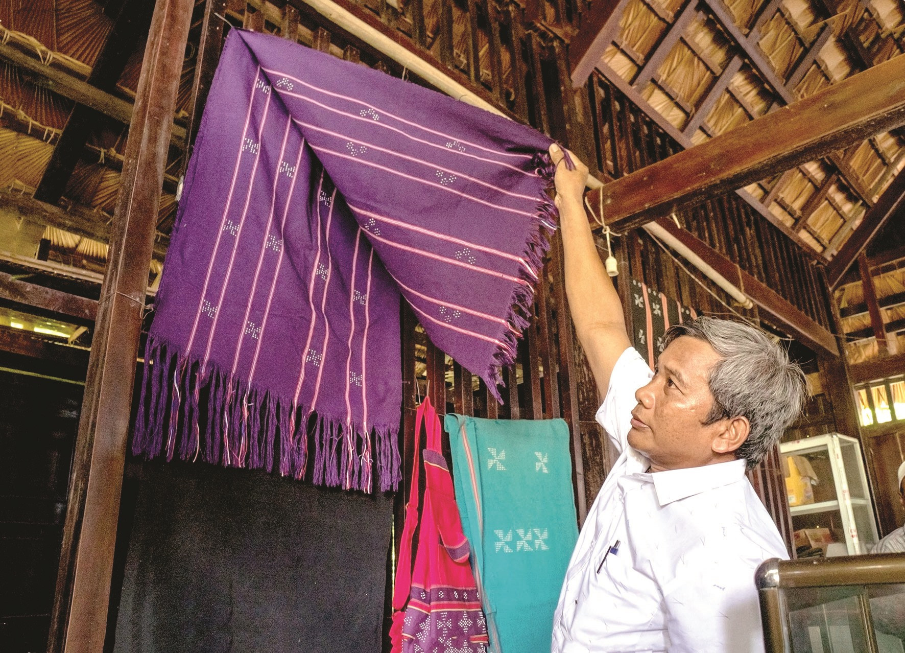 Ông Pơ Long Trớt - Phó Trưởng ban Tuyên giáo Huyện ủy Nam Giang giới thiệu các sản phẩm của làng dệt Zara.