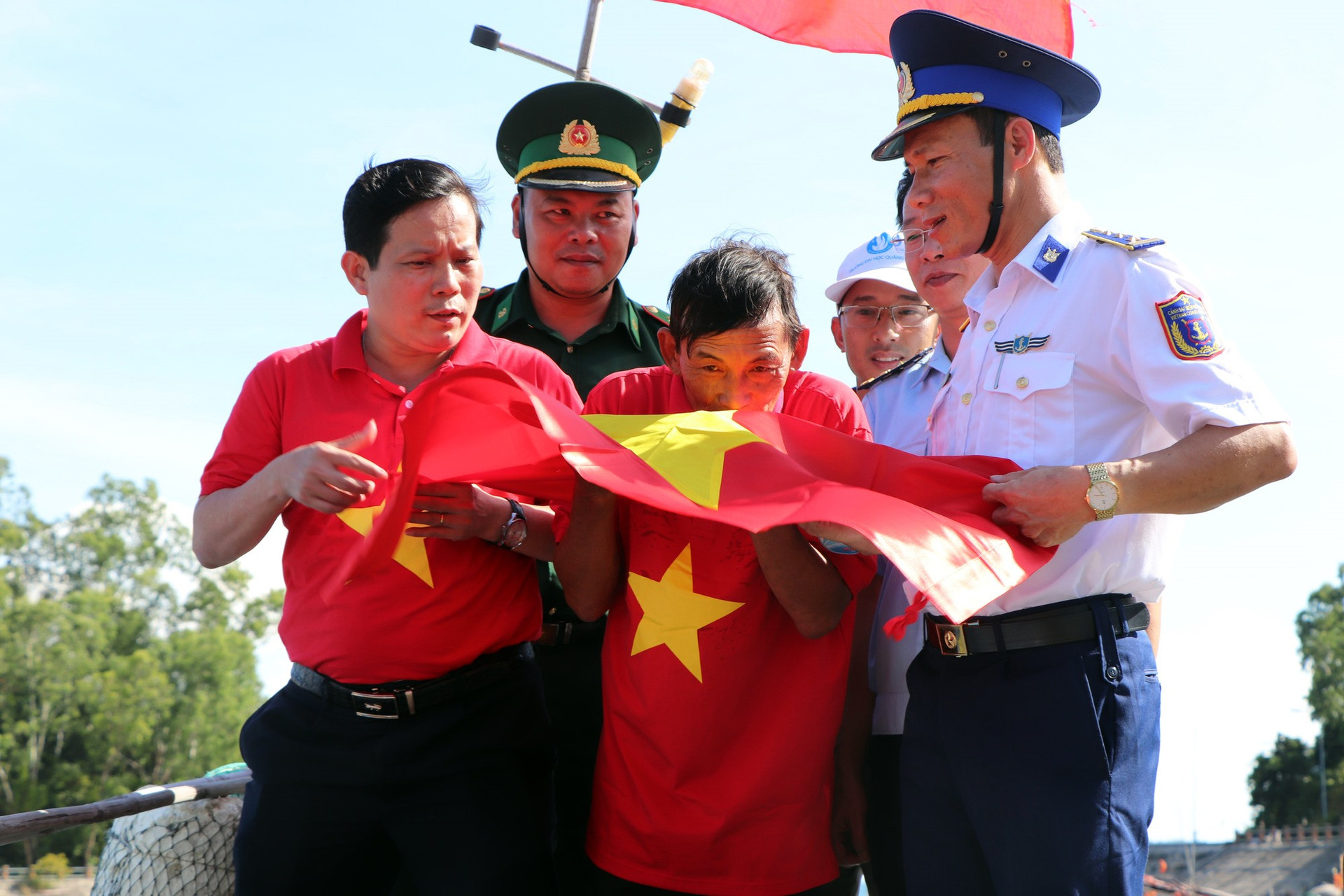 Ngư dân tại xã Tân Hiệp, TP Hội An xúc động nhận cờ Tổ quốc.