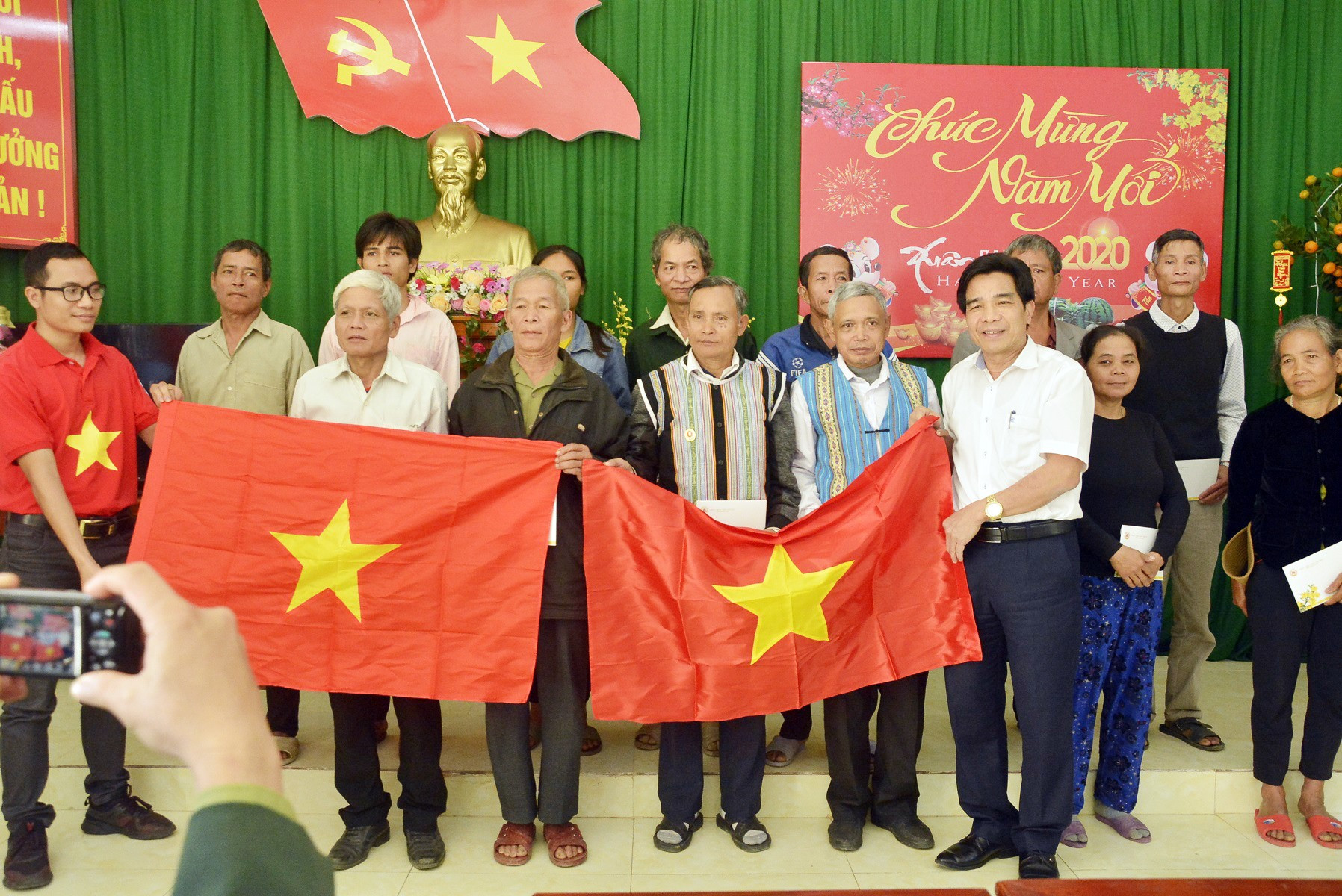 Đồng chí Lê Văn Dũng, Phó Bí thư Thường trực Tỉnh ủy, Trưởng đoàn Đại biểu Quốc hội tỉnh trao cờ Tổ quốc cho đồng bào biên giới huyện Nam Giang tháng 1-2020.