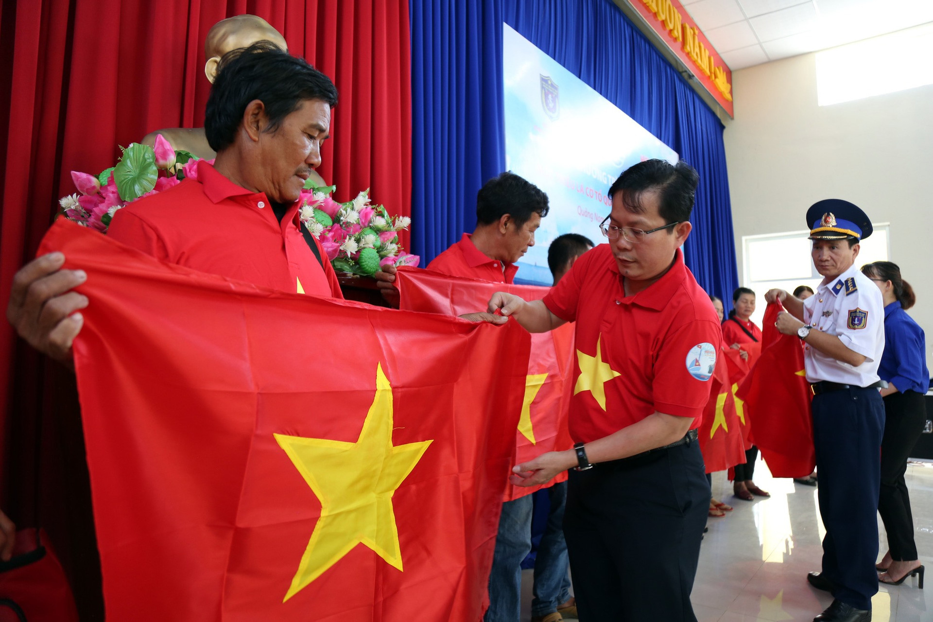 Ông Tô Đình Tuân, Tổng Biên tập Báo Người Lao Động cùng đại tá Lê Huy Sinh, Chính ủy Bộ Tư lệnh Vùng Cảnh sát biển 2 trao cờ Tổ quốc và túi thuốc y tế cho ngư dân huyện Núi Thành tháng 7-2020.