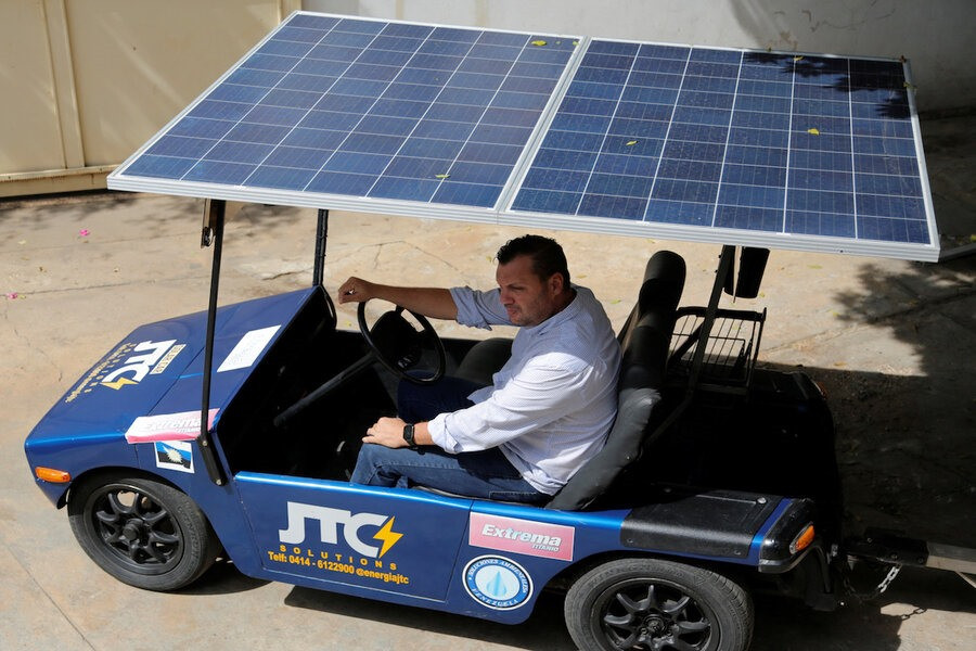 Jose Cintron ngồi trong một chiếc ô tô chạy bằng năng lượng mặt trời do ông thiết kế. Ảnh: Reuters