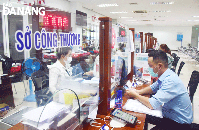 Thành phố đang đẩy mạnh quá trình chuyển đổi số để người dân ứng dụng công nghệ thông tin vào cuộc sống. TRONG ẢNH: Người dân đến giao dịch tại bộ phận “Một cửa” Trung tâm Hành chính thành phố có thể sử dụng máy tính bảng để tra cứu thông tin phục vụ tốt nhu cầu giải quyết thủ tục hành chính. Ảnh: P.V