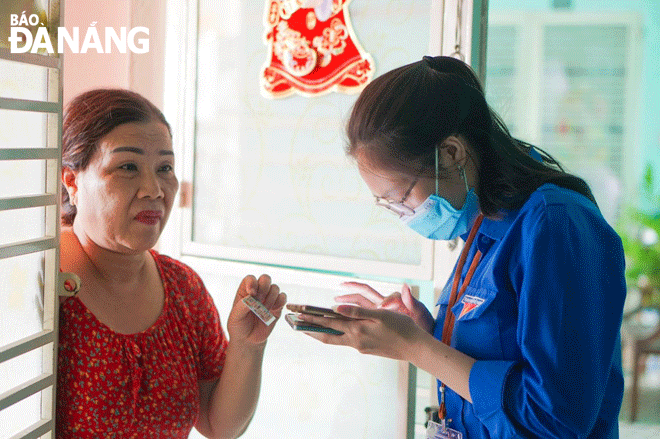 Thành phố đang từng bước xây dựng mô hình chính quyền số, công dân số, đem lại nhiều lợi ích cho người dân, doanh nghiệp. TRONG ẢNH: Đoàn viên, thanh niên quận Sơn Trà (bên phải) hướng dẫn người dân sử dụng các dịch vụ công điện tử. Ảnh: QUỲNH TRANG