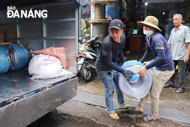 Các vật dụng như dây cáp, tăng đơ, ốc siết, bao bì, bạt che chắn... được tiêu thụ mạnh. Trong ảnh: Nhân viên cửa hàng Mười Bi (số 60 đường Nguyễn Trãi) bốc xếp dây cáp ra xe cho khách hàng mua về bán lẻ vào sáng 26-9. Ảnh: KHÁNH HÒA
