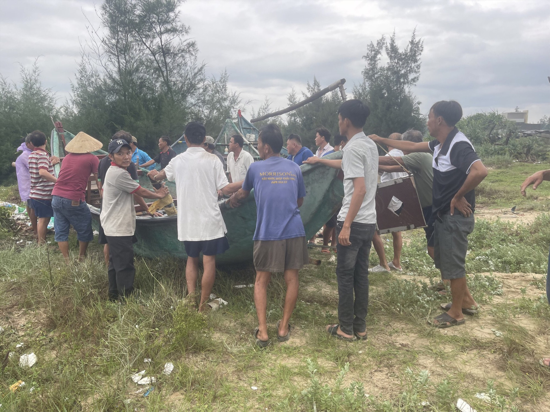 Tại xã Bình Nam, người dân hỗ trợ nhau đưa tàu, thuyền vào nơi tránh trú an toàn