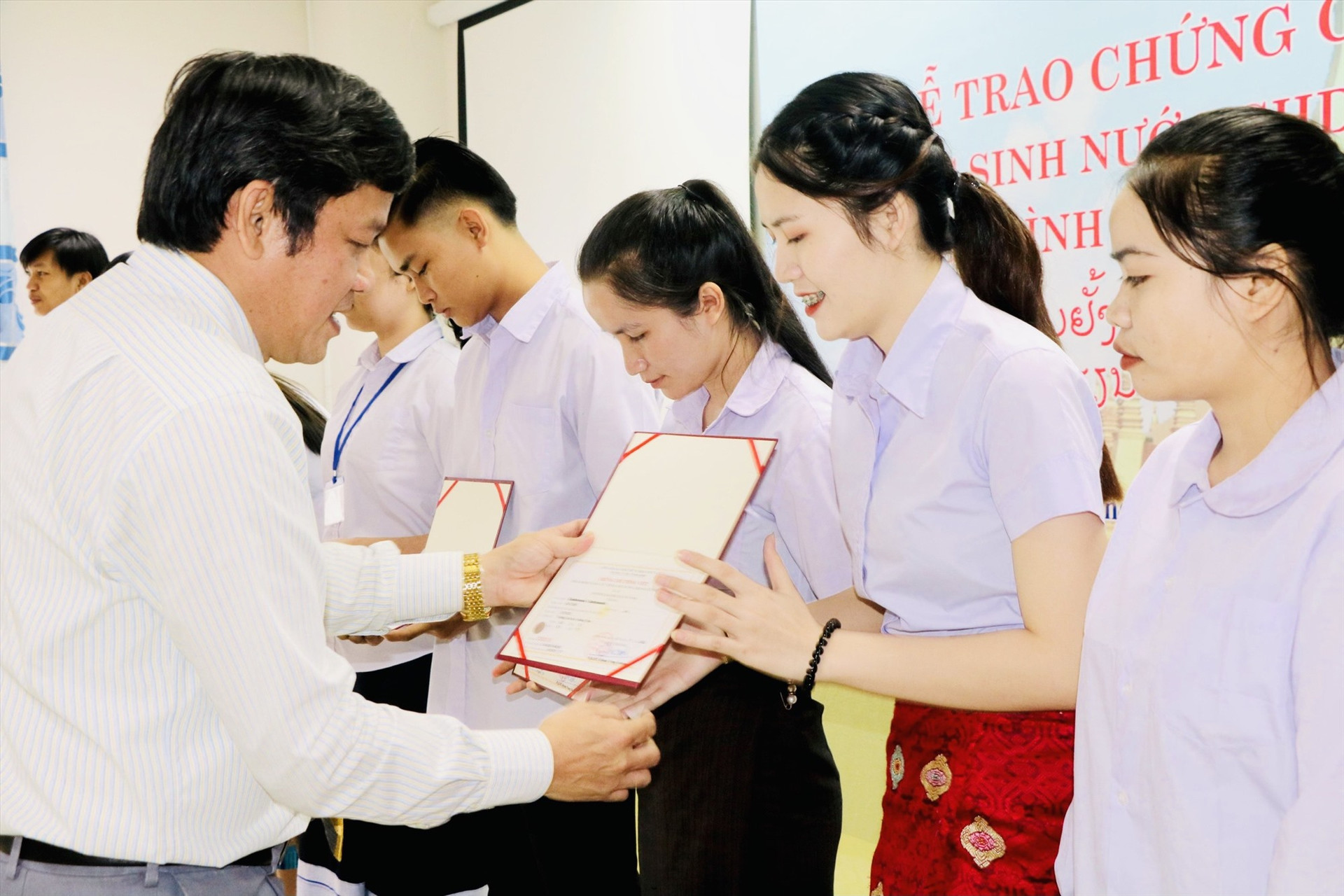 PGS.TS Huỳnh Trọng Dương – Hiệu trưởng Trường Đại học Quảng Nam trao chứng chỉ tiếng Việt cho lưu học sinh Lào. Ảnh: ĐINH HÙNG