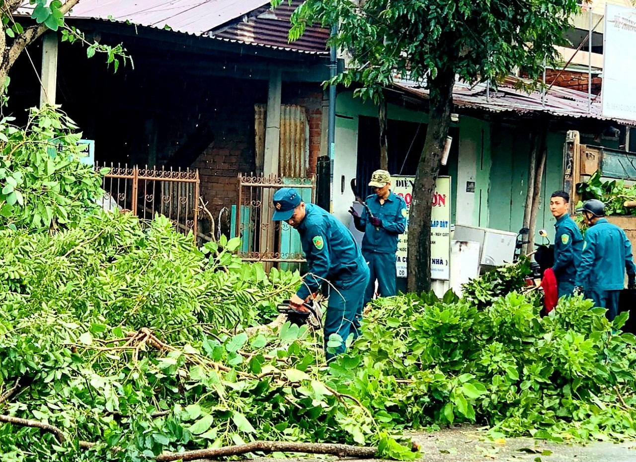 Lực lượng dân quân thường trực xã Duy Sơn cưa dọn cây cối ngã đổ sau bão.