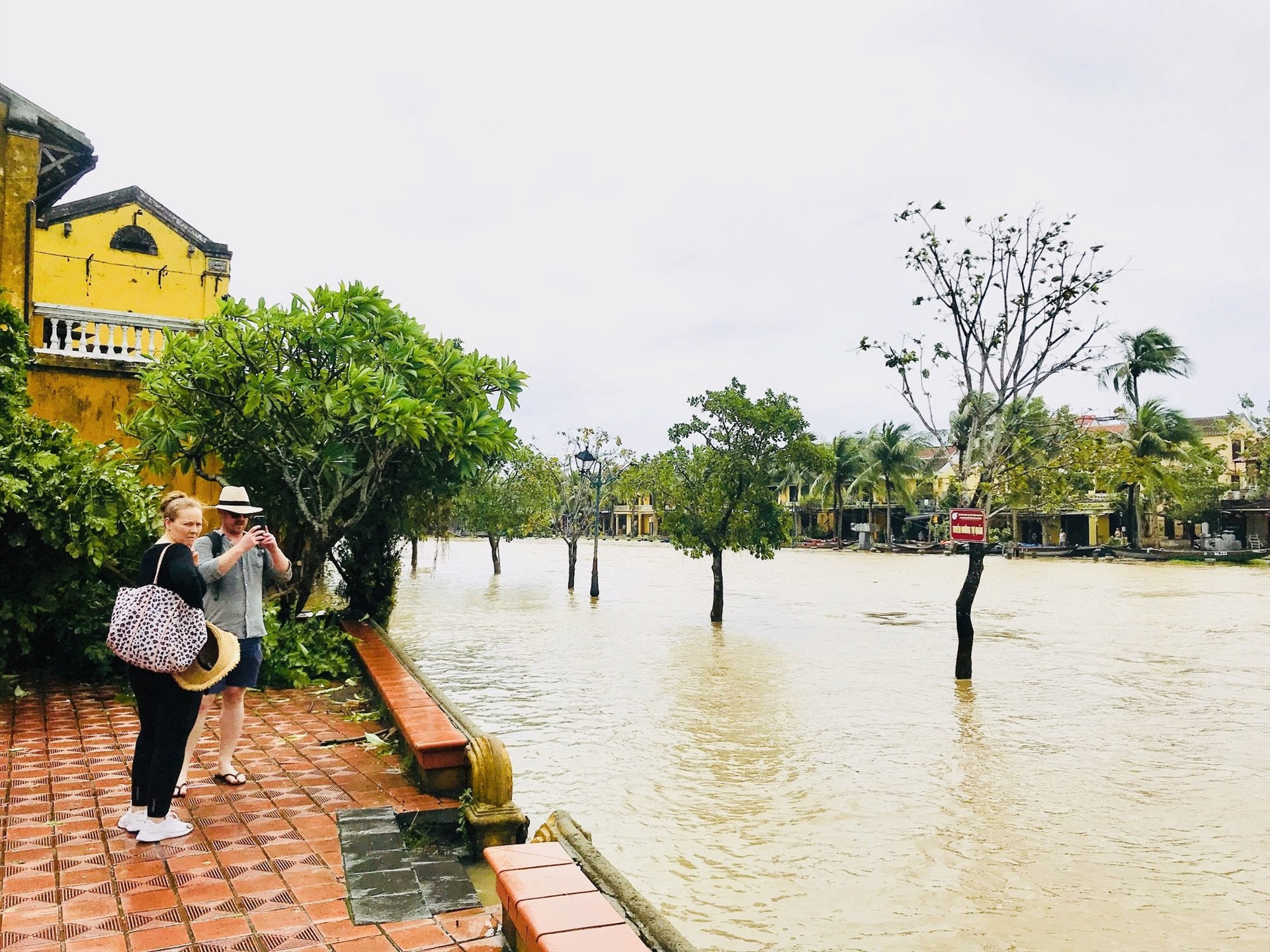 Một số du khách quốc tế ghi lại cảnh nước sông Hoài dâng lên đường Bạch Đằng