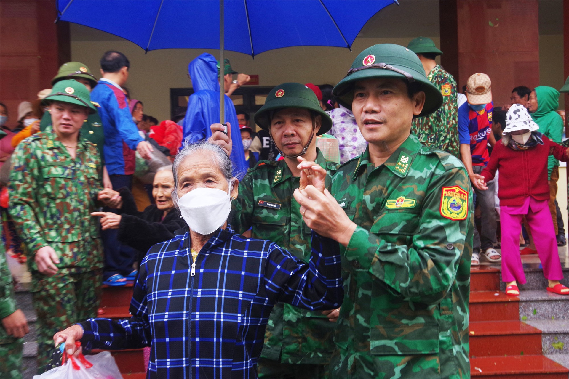 Đại tá Hoàng Văn Mẫn – Chính ủy BĐBP tỉnh Quảng Nam (bên phải) có mặt từ sáng sớm đưa bà con về lại với gia đình. Ảnh: HỒNG ANH