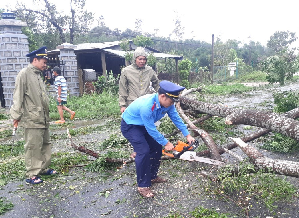 Lực lượng Thanh tra Sở GTVT cưa cây cối ngã đổ để thông tuyến ĐT611 qua Quế Sơn. Ảnh: K.K