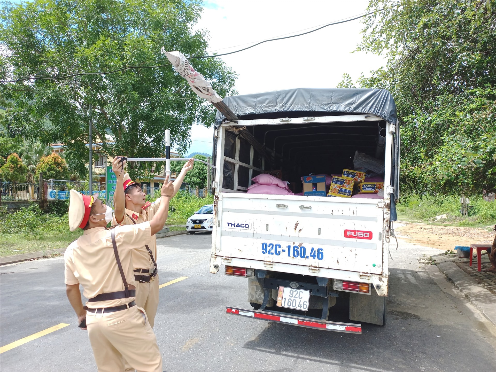 Tổ tuần tra của Đội CSGT - Trật tự Công an huyện Nam Giang kiểm tra xe tải chở quá kích thước thành, thùng hàng. Ảnh: SC