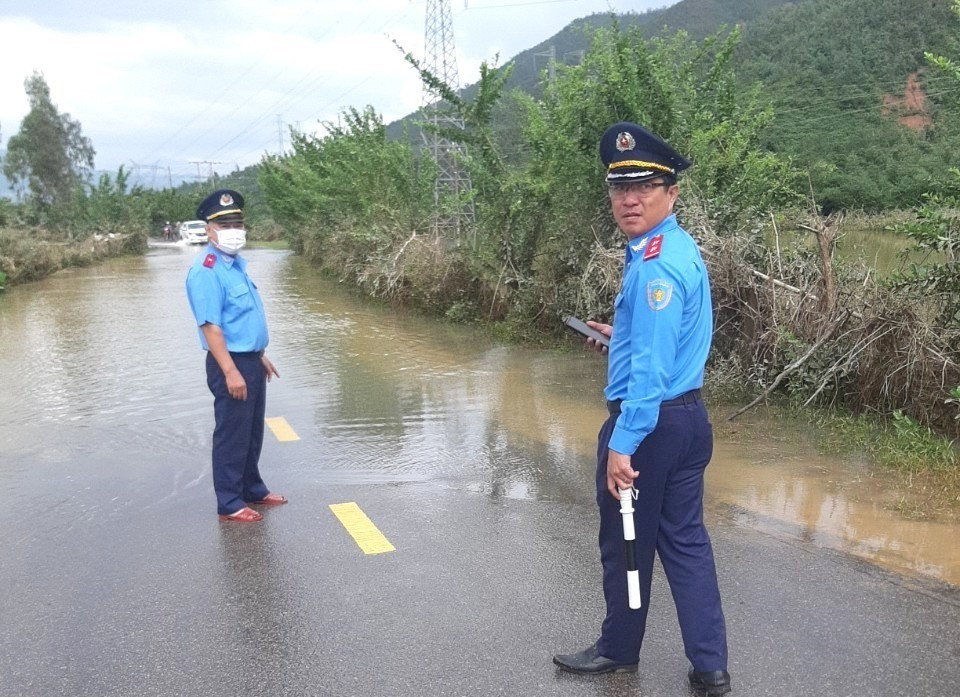 Thanh tra Sở GTVT điều tiết giao thông vị trí nước lũ còn băng qua trên tuyến ĐT609, thuộc địa phận huyện Đại Lộc. Ảnh: MH