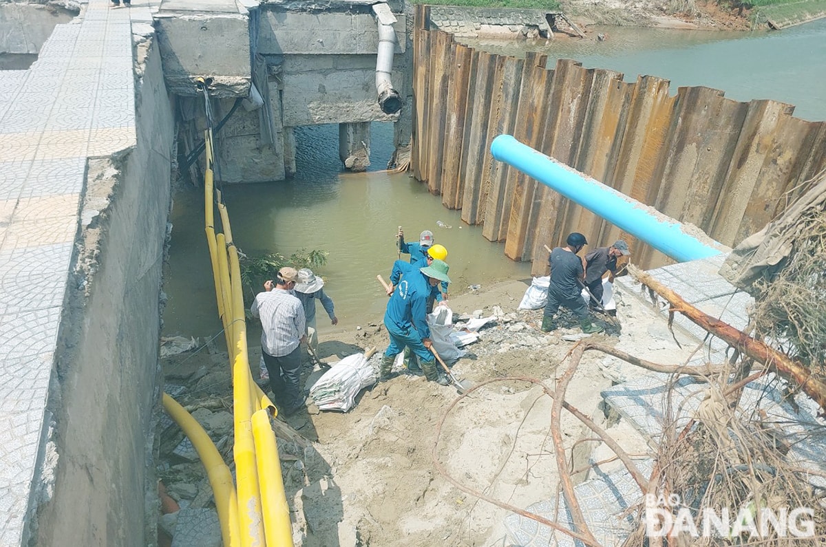 Công nhân được huy động xử lý đất, cát sạt lở trước khi triển khai các bước tiếp theo.