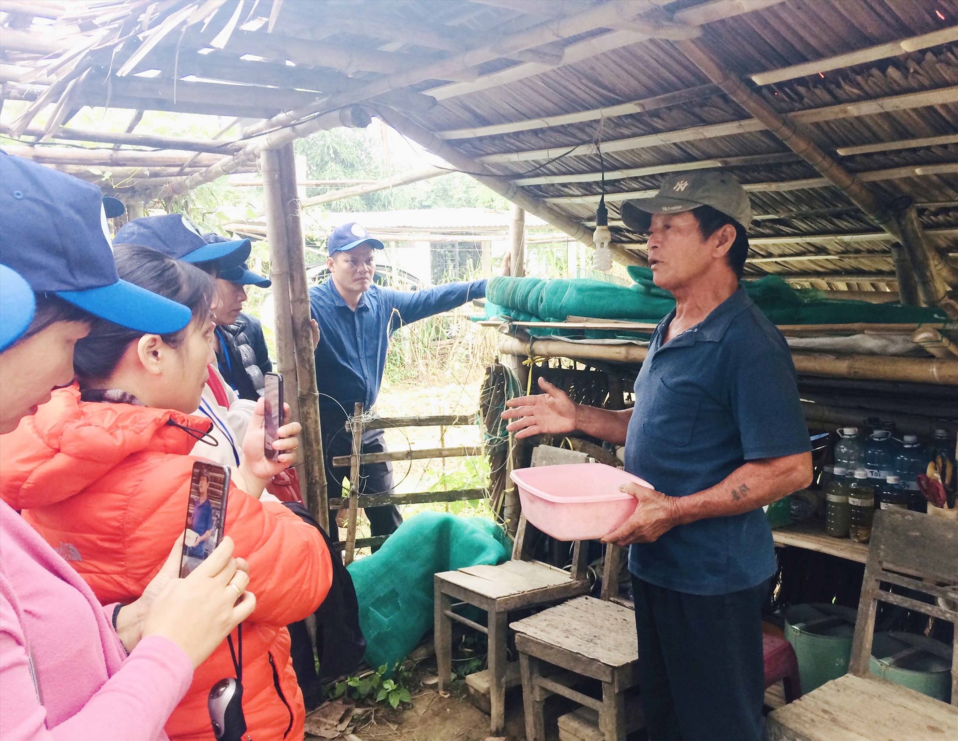 Một đoàn khách tìm hiểu quy trình canh tác nông nghiệp hữu cơ từ nông dân địa phương. Ảnh: Q.T