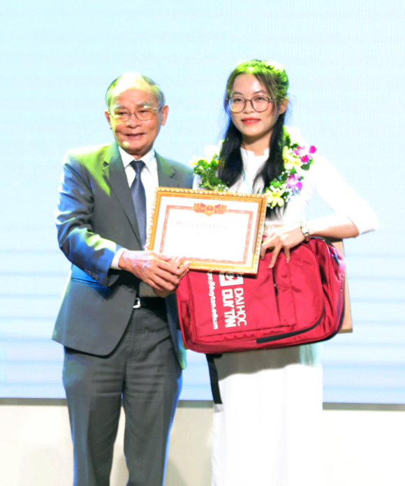 Nhà giáo ưu tú Lê Công Cơ trao tặng học bổng toàn phần cho thủ khoa năm 2022 Đinh Thị Hoài Nhi. Ảnh: Q.L