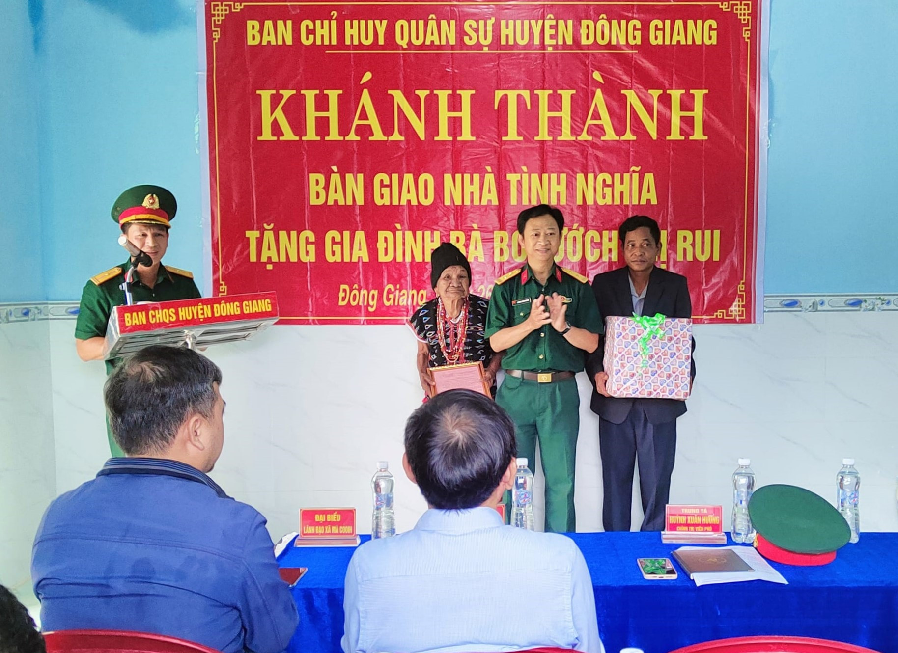 Đại diện Ban Chỉ huy Quân sự huyện Đông Giang tặng quà động viên cho gia đình bà Bh'nướch Thị Rui. Ảnh: V.R