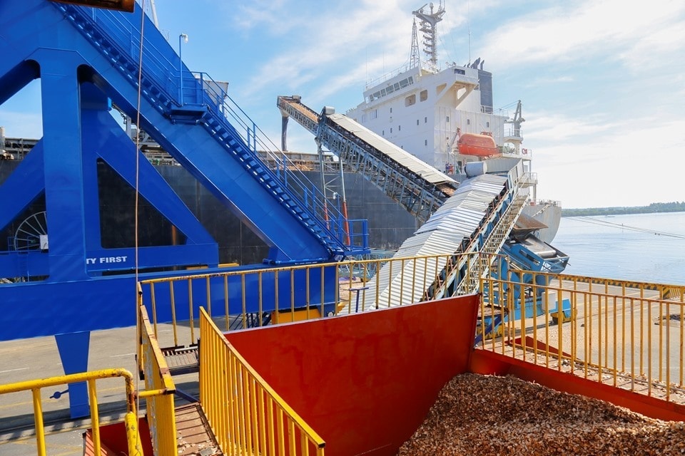 A conveyor belt moving wood shavings to a ship