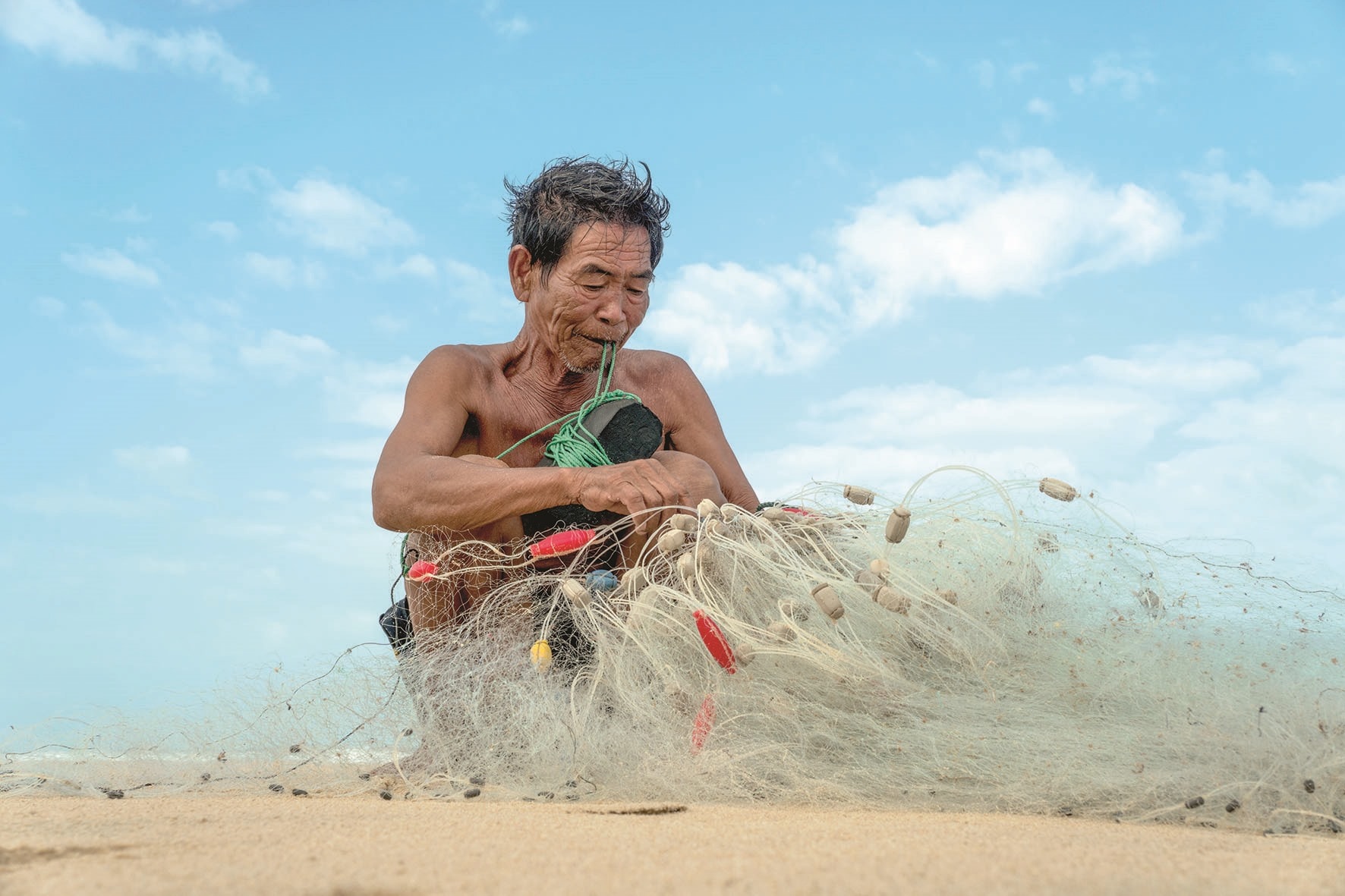 Lão ngư Võ Văn Lân kiểm tra lưới trước khi thả ra biển.