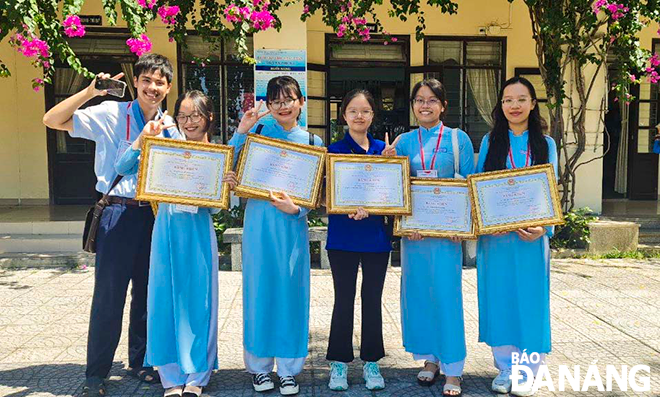 Phạm Võ Bảo Nguyên (thứ 3, bên phải sang) nhận giấy khen của Trường THPT chuyên Lê Quý Đôn. Ảnh: Đ.G.H