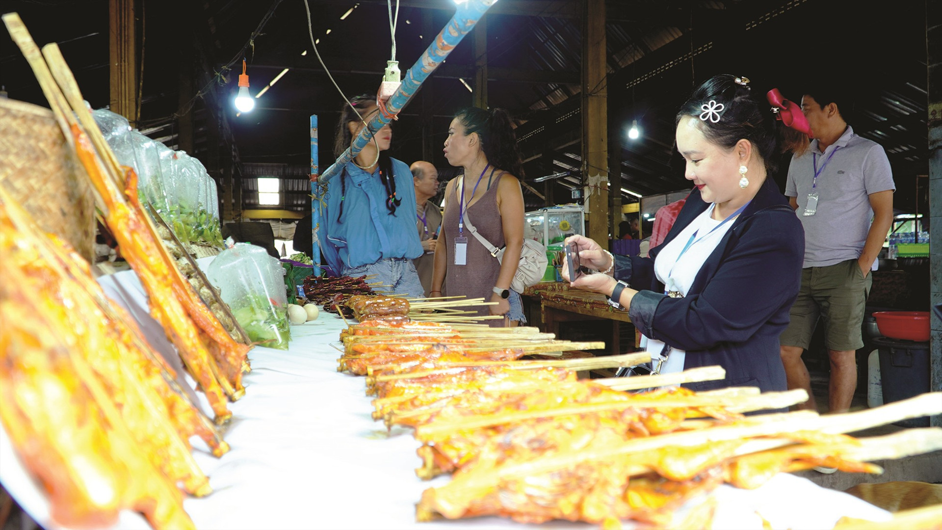 Chị Trương Thị Thủy Trinh (Quảng Nam) lần đầu tiên du lịch Nam Lào tỏ ra rất thích thú với ẩm thực độc đáo chợ quê.