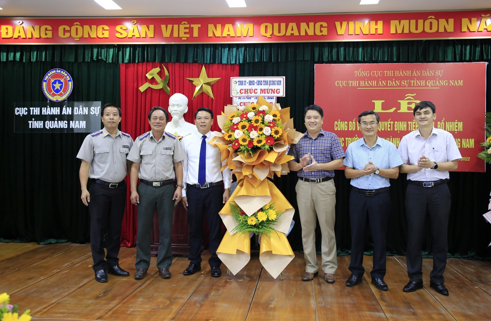 Phó Chủ tịch UBND tỉnh Trần Văn Tân tặng hoa chúc mừng ông Mai Văn Sang (thứ ba từ trái qua) được bổ nhiệm Phó Cục trưởng Cục thi hành án dân sự tỉnh.