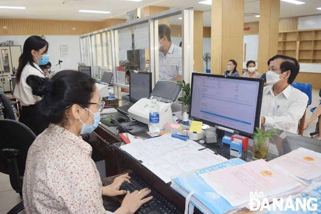 Từ cơ sở dữ liệu đất đai đã được số hóa, chuyên viên Chi nhánh Văn phòng Đăng ký đất đai quận Sơn Trà giải quyết hồ sơ cấp giấy chứng nhận quyền sử dụng đất trực tuyến cho công dân. Ảnh: HOÀNG HIỆP