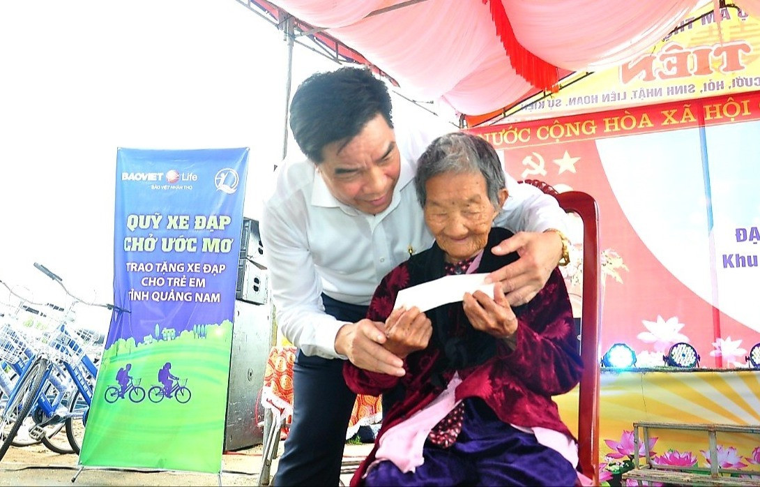 Đồng chí Lê Văn Dũng trao quà cho người cao tuổi ở thôn An Lộc. Ảnh: S.A