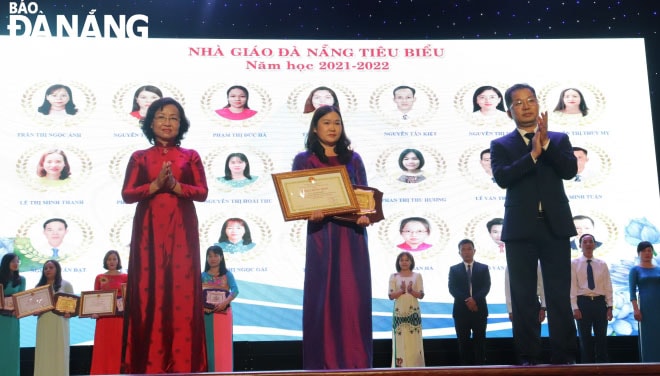 Bí thư Thành ủy Nguyễn Văn Quảng (bìa phải) và Phó Chủ tịch UBND thành phố Ngô Thị Kim Yến (bài trái) tặng danh hiệu nhà giáo tiêu biểu Đà Nẵng cho các giáo viên. Ảnh: NGỌC HÀ