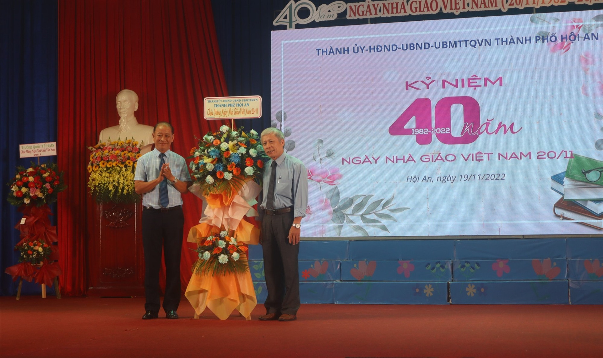 Bí thư Thành ủy Hội An (trái) tặng hoa chúc mừng Ngày Nhà giáo Việt Nam cho các thầy, cô. Ảnh: Q.T
