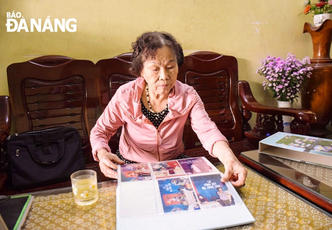 Nhà giáo ưu tú Trần Thị Minh Thê bồi hồi xúc động khi xem lại các bức ảnh lưu giữ kỷ niệm những năm tháng dạy học. Ảnh: Đ.H.L