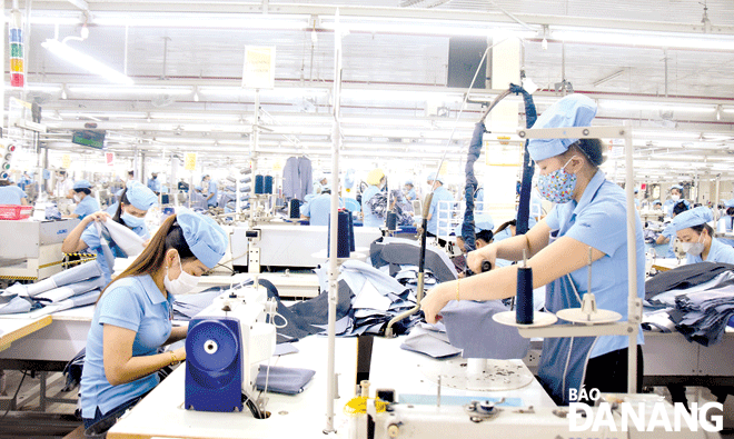 Công nhân đang sản xuất tại Tổng Công ty CP Dệt may Hòa Thọ. Ảnh: QUỲNH TRANG