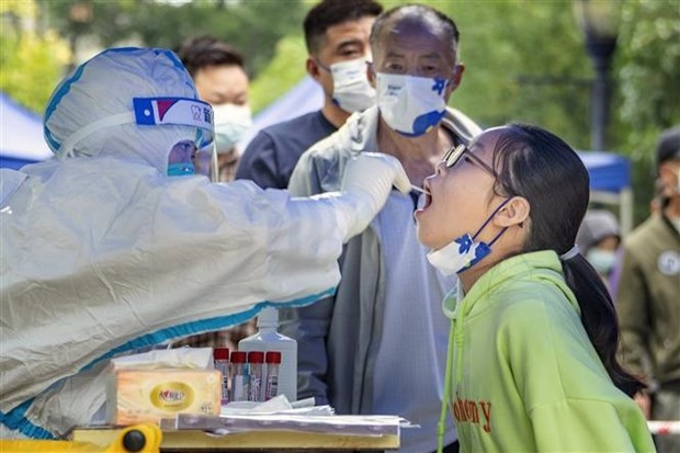 Nhân viên y tế lấy mẫu xét nghiệm COVID-19 cho người dân tại Tứ Xuyên, Trung Quốc. Ảnh: AFP/TTXVN