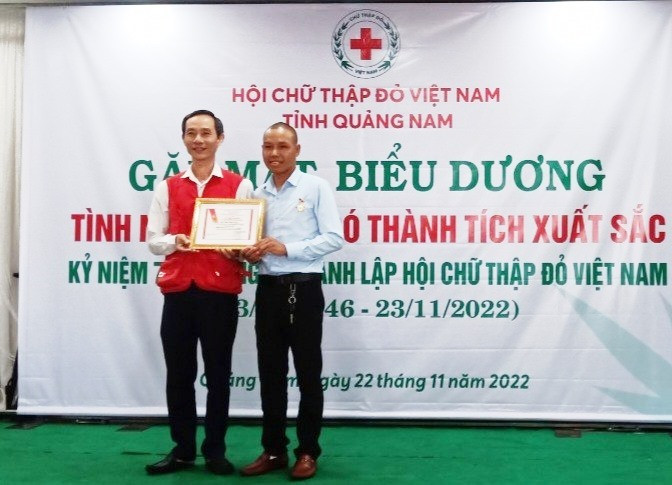 Ông Lê Tấn Minh - Chủ tịch Hội CTĐ trao kỷ niệm chương cho tình nguyện viên có đóng góp xuất sắc trong phong trào. Ảnh: H.L