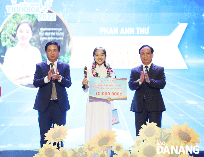Phó Bí thư Thường trực Thành ủy Lương Nguyễn Minh Triết (bên trái) và Giám đốc Đại học Đà Nẵng Nguyễn Ngọc Vũ (bên phải) trao hoa và biểu trưng cho thủ khoa năm học 2022-2023. Ảnh:NGỌC HÀ