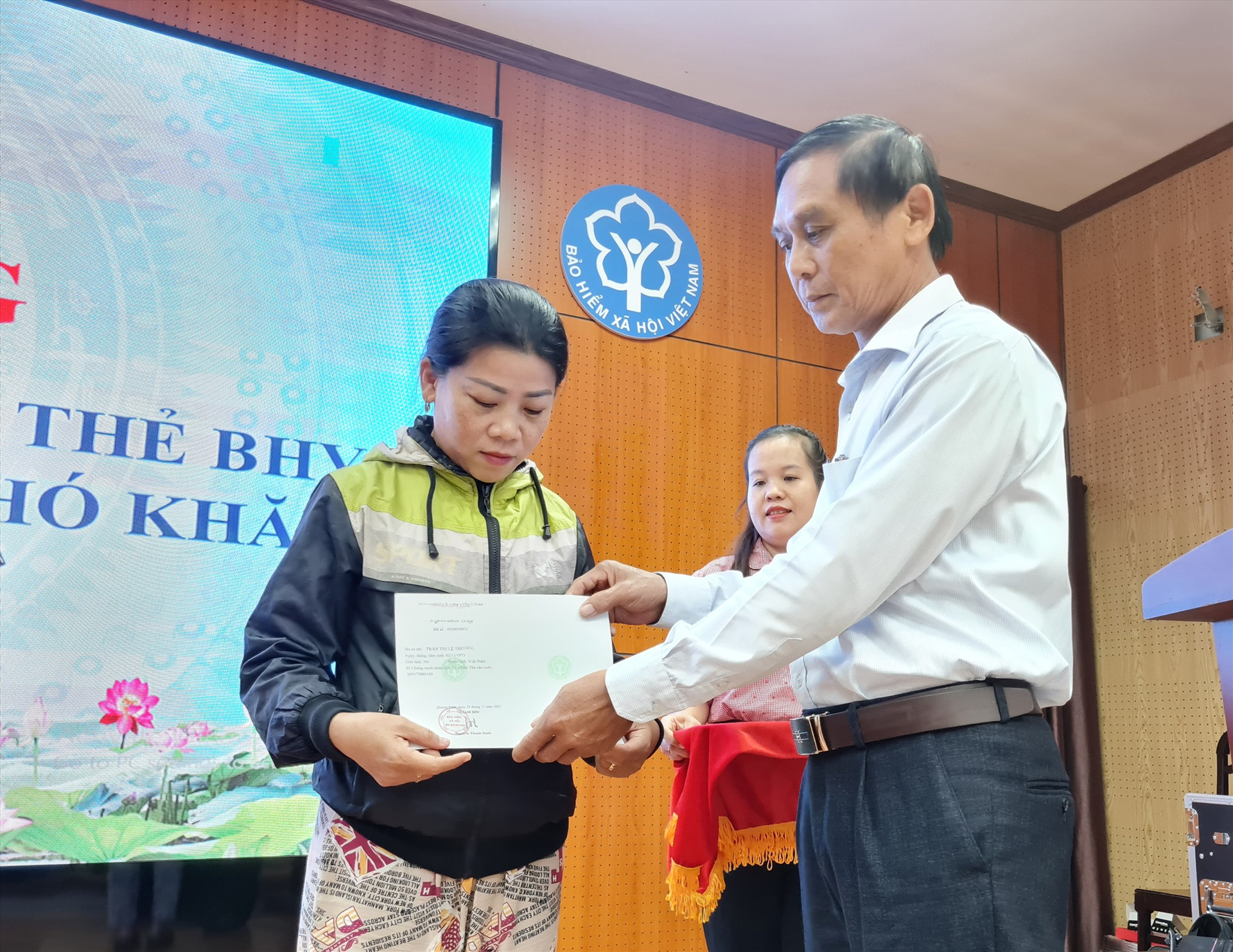 Bà Trần Thị Lệ Thương nhận sổ bảo hiểm xã hội tại lễ phát động chương trình của Bảo hiểm Xã hội Việt Nam. Ảnh: D.L