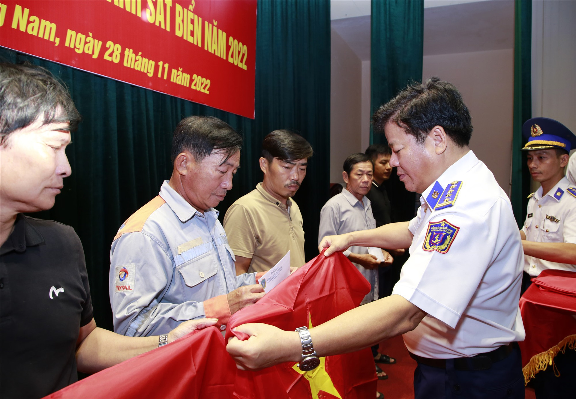 Lãnh đạo Bộ Tư lệnh Vùng Cảnh sát biển 2 trao tặng cờ Tổ quốc cho ngư dân. Ảnh: T.C
