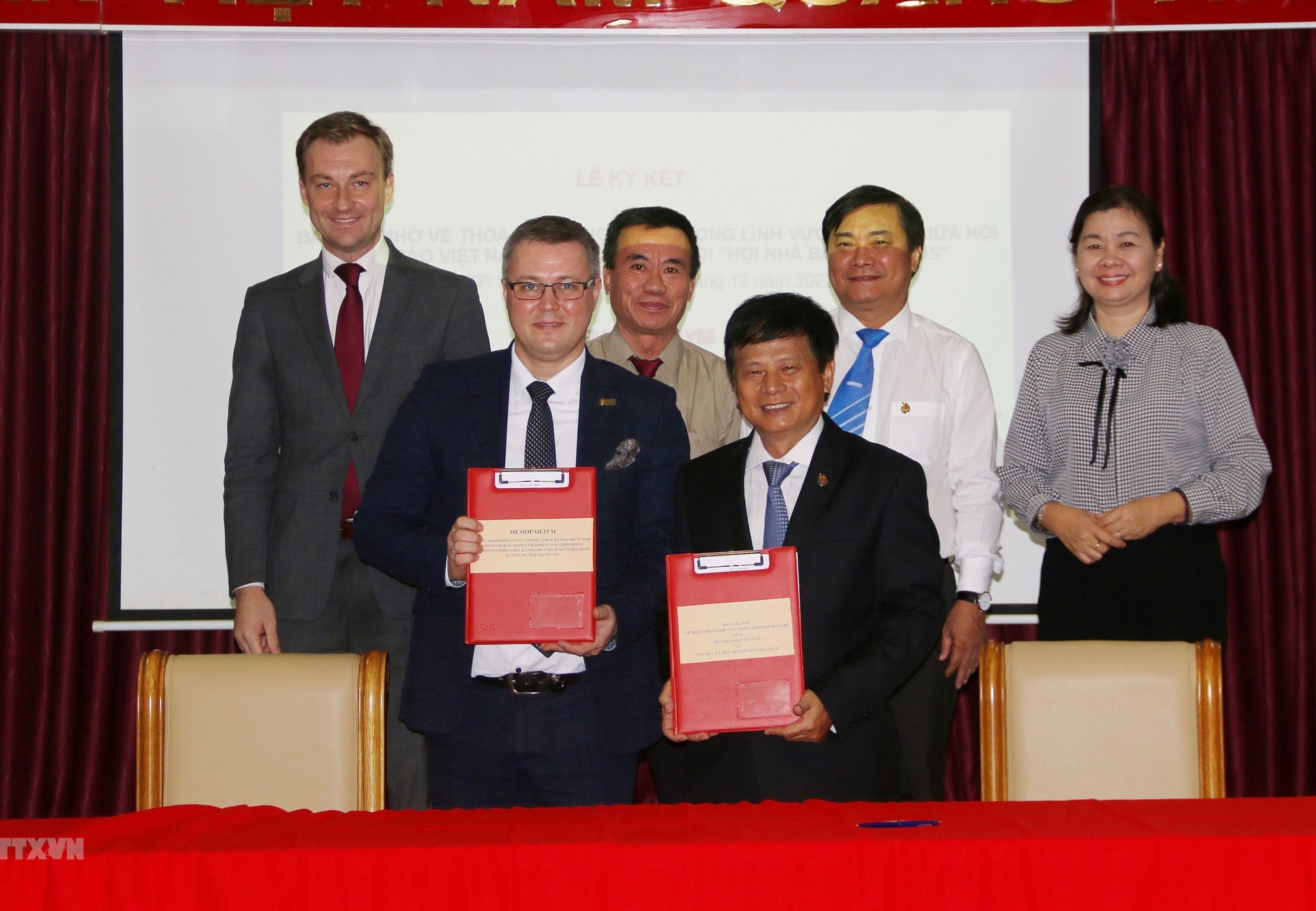 Phó Chủ tịch Hội Nhà báo Việt Nam Trần Trọng Dũng (phải) và ông Andrei Kryvasheyeu, Chủ tịch Hội đồng Quản trị Tổ chức xã hội Hội nhà báo Belarus (trái) thực hiện nghi thức ký kết bản ghi nhớ thỏa thuận hợp tác trong lĩnh vực báo chí. (Ảnh: Thanh Vũ/TTXVN)