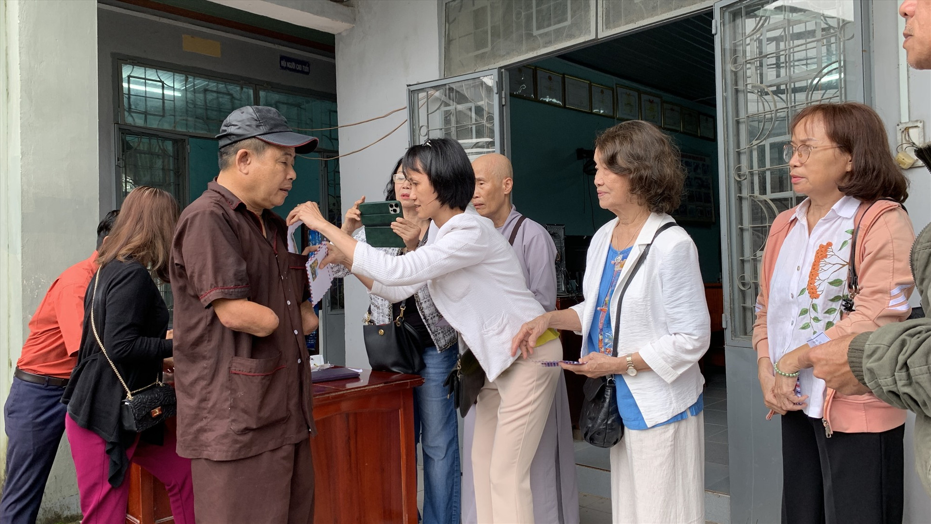 Đoàn thiện nguyện tặng quà các hội viên Hội Người mù ở Nông Sơn. Ảnh MINH THÔNG