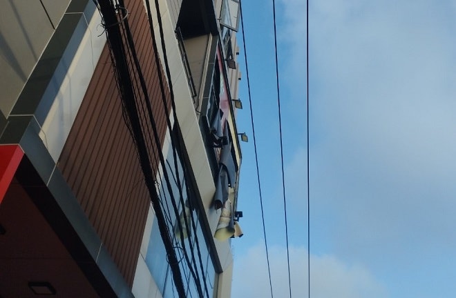 Lắp bảng hiệu trước số nhà 254 Đống Đa vi phạm khoảng cách an toàn lưới điện.