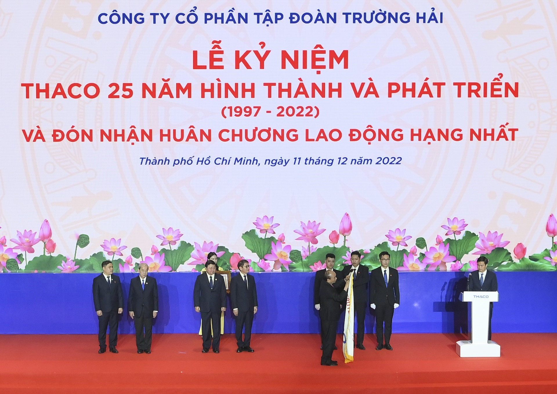 Chủ tịch nước Nguyễn Xuân Phúc gắn Huân chương Lao động hạng Nhất lên lá cờ truyền thống của THACO. Ảnh: TTXVN