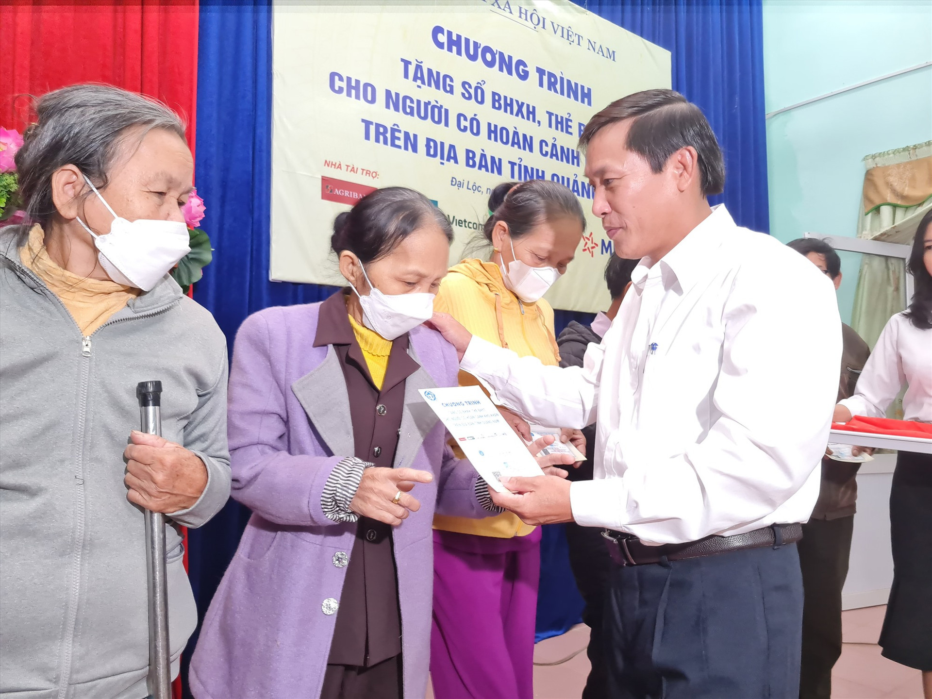Lãnh đạo UBND huyện Đại Lộc tặng thẻ BHYT cho người dân. Ảnh: D.L