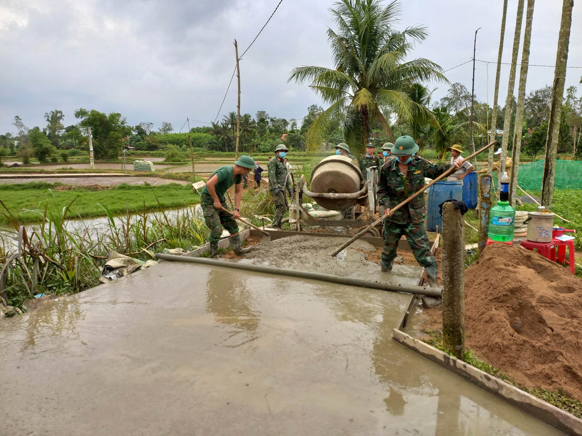 Bộ đội giúp dân làm đường bê tông nông thôn tại thôn Sơn Lộc, xã Quế Minh. ảnh DT