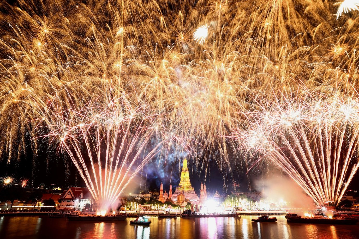 Fireworks explode over the Chao Phraya River in Bangkok, Thailand