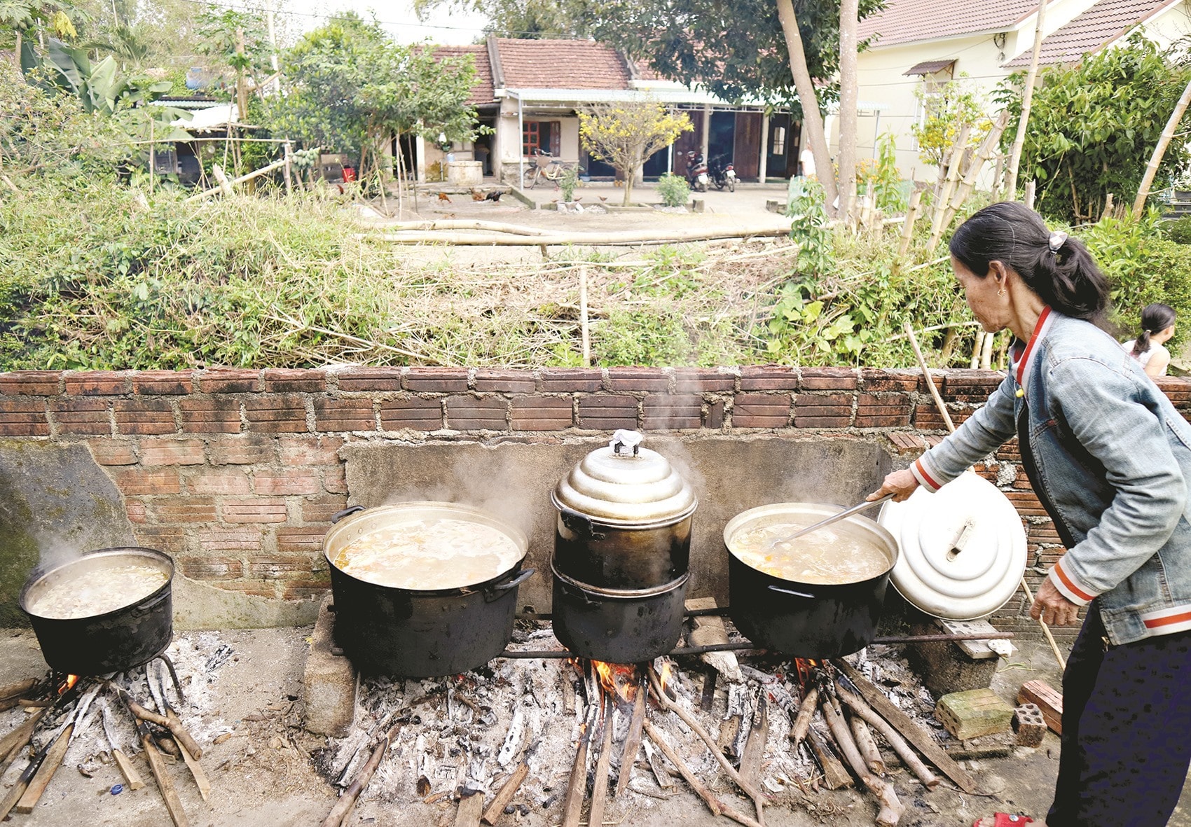 Trong ngày chạp mả, các cô, các chị chung tay lo việc bếp núc, trách nhiệm nặng nề nhất là những nàng dâu. Ảnh: PHƯƠNG THẢO