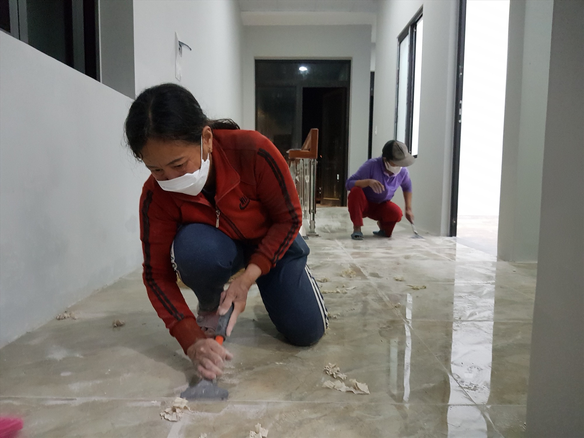 Các công nhân của bà Trà Thị Hậu (47 tuổi, phường An Mỹ, TP.Tam Kỳ) đang dọn nhà cho anh Lê Văn Lâm kịp đón tết. Ảnh: KL