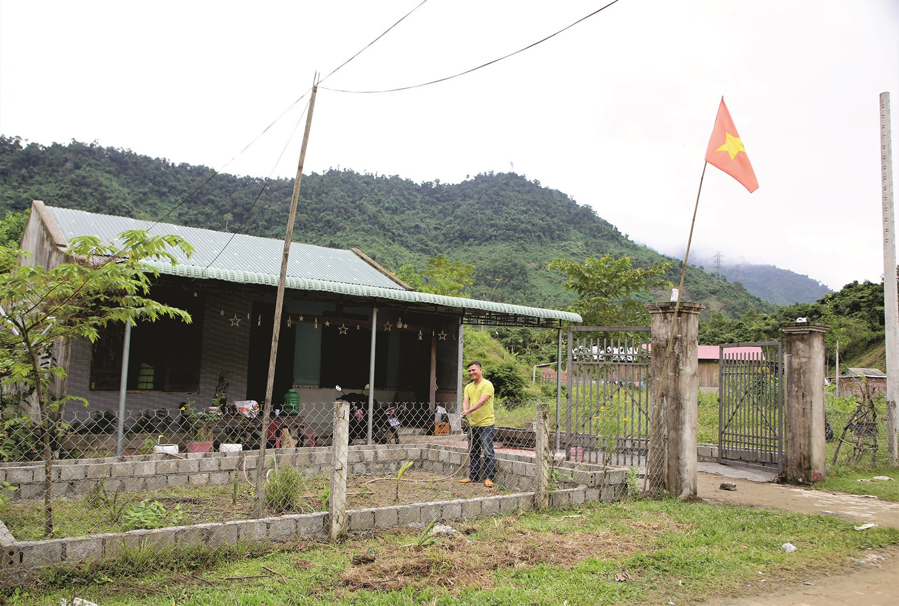 Một hộ dân ở thôn Pà Ong (xã Cà Dy, Nam Giang) tưới đất chuẩn bị trồng hoa trước nhà.