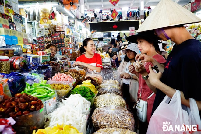 Du khách trải nghiệm tại quầy hàng bán bánh, kẹo, mứt.Ảnh: K.T